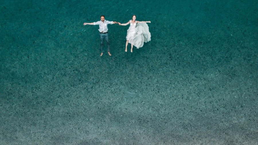 man and woman floating on blue beach