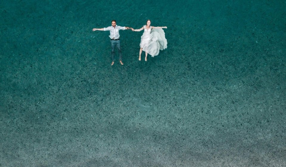 man and woman floating on blue beach