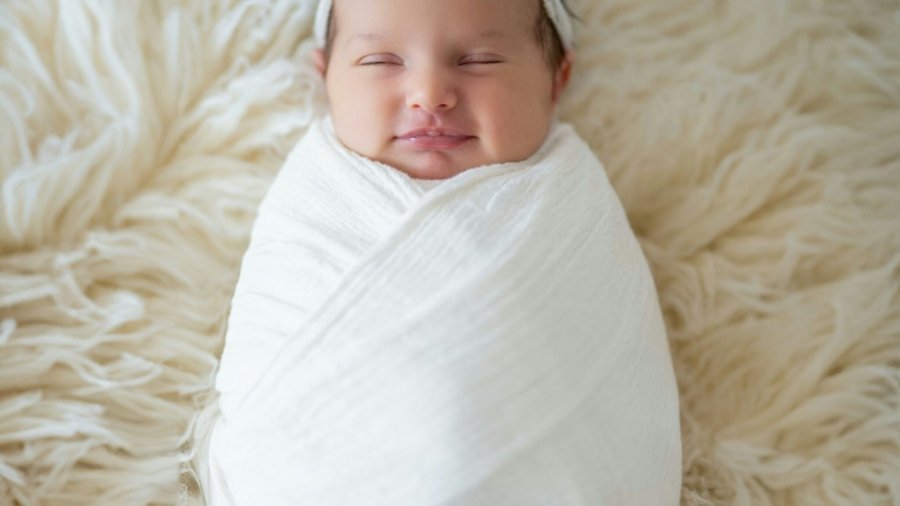 a newborn baby wrapped in a white blanket