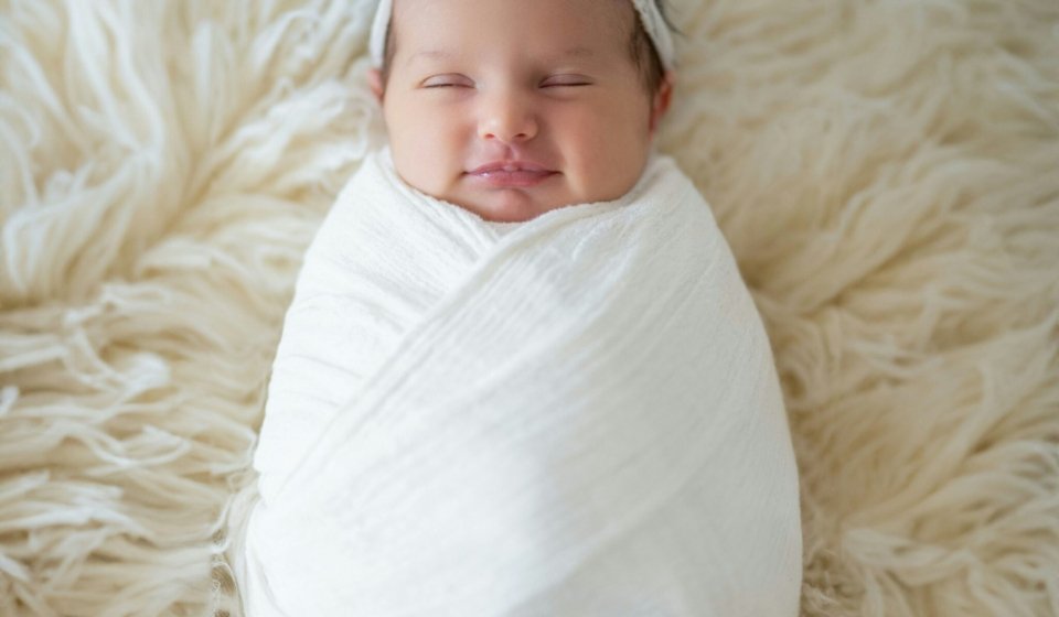 a newborn baby wrapped in a white blanket